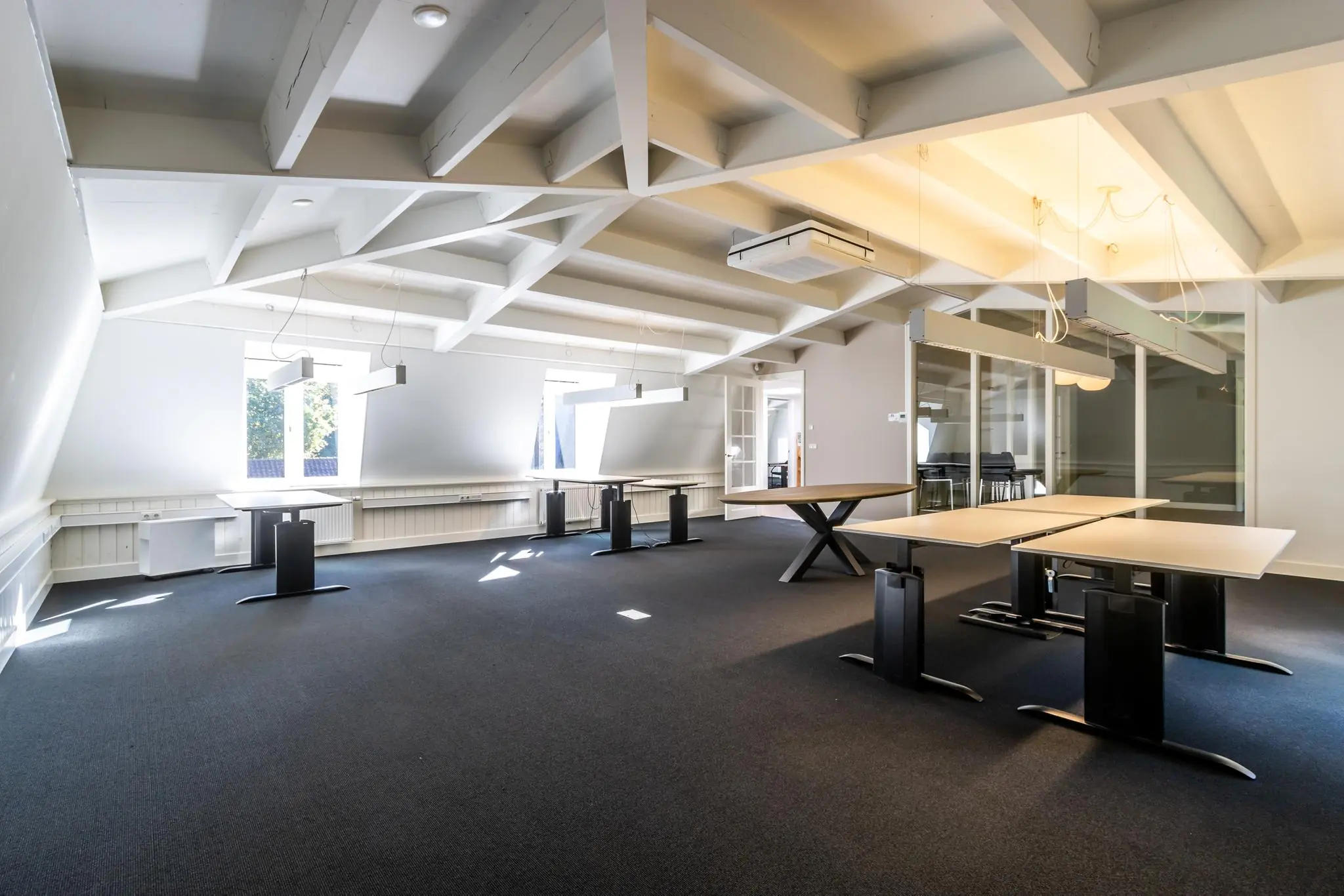 Modern ingerichte kantoorruimte aan de Langbroekerdijk met hoog plafond, bureaus en veel daglicht.